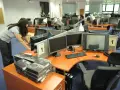 Kobieta przygotowuje stanowiska pracy w biurze. Czy to początek kariery, która okaże się najbardziej opłacalny zawód?
