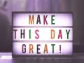 Świecąca tablica z napisem "MAKE THIS DAY GREAT!" dodaje motywacji do pracy.