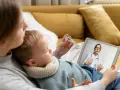 Mama mierzy temperaturę dziecku, konsultując się z lekarzem online. L4 na dziecko przez teleporadę.