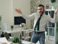 Szczęśliwy ENFP w pracy, tańczący w słuchawkach. W tle biuro z roślinami i komputerami.