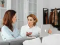 Kobiety omawiają wynagrodzenie za urlop, analizując dane na laptopie.