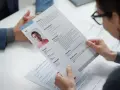 Kobieta przegląda wzór CV z profesjonalnym zdjęciem kandydata, gotowa do oceny jego kwalifikacji.