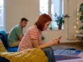 Kobieta zapatrzona w telefon, ignoruje partnera. Czy to początek problemów, jak rozmawiać z toksykiem?
