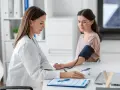 Lekarka mierzy ciśnienie pacjentce. Wynik l4 powyżej 30 dni wymaga dalszej diagnostyki.