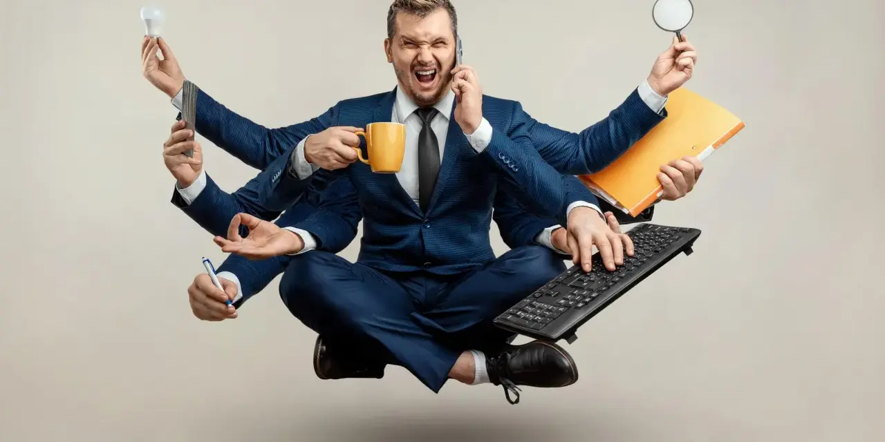 Biznesmen z wieloma rękami, przytłoczony nadmierną kontrolą w pracy, trzyma kubek kawy, telefon, żarówkę, lupę, klawiaturę i długopis.