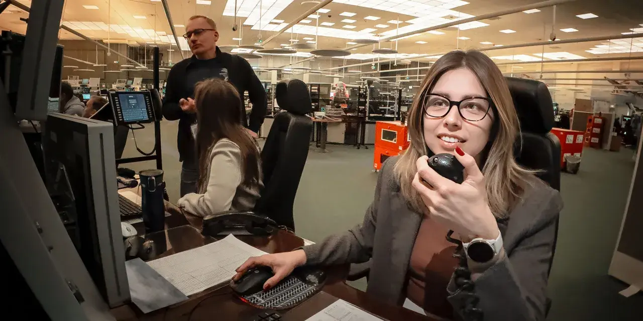 Kontroler ruchu lotniczego w akcji, komunikuje się przez radio, monitorując przestrzeń powietrzną.