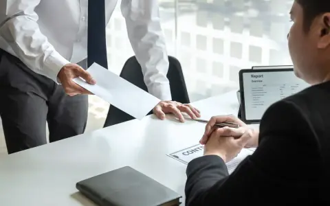 Pracodawca wręcza kopertę, a pracownik patrzy na dokumenty. Czy pracodawca może zmusić do urlopu?