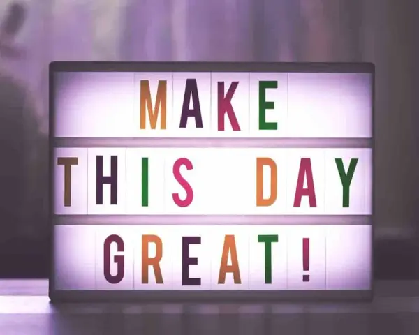 Świecąca tablica z napisem "MAKE THIS DAY GREAT!" dodaje motywacji do pracy.