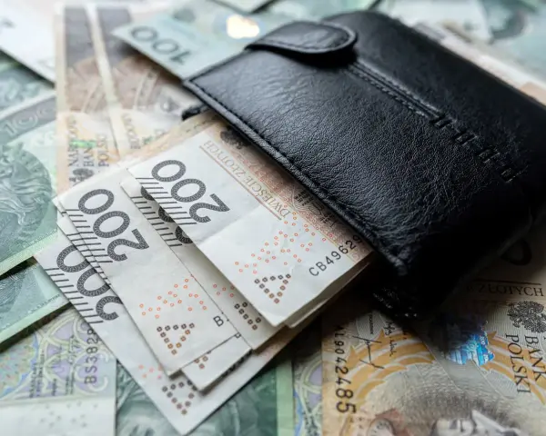 Czarny portfel na stosie polskich banknotów 200 zł. Wiele wskazuje na podwyżkę najniższej krajowej.