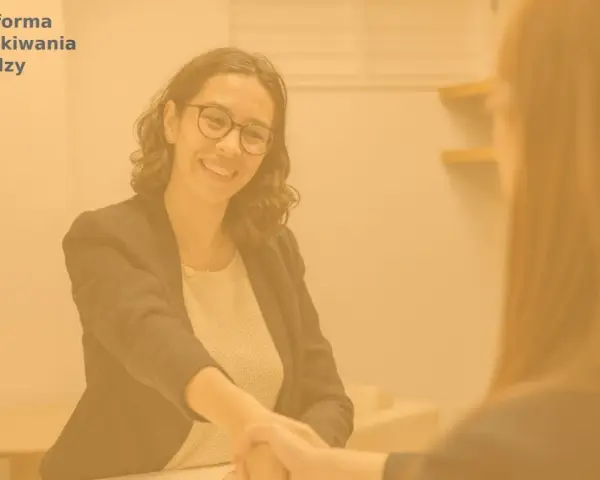 Uśmiechnięta kobieta po 40. zawiera umowę o pracę, symbolizując udaną zmianę pracy.