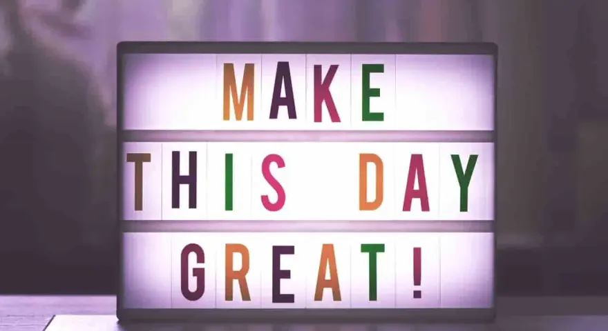 Świecąca tablica z napisem "MAKE THIS DAY GREAT!" dodaje motywacji do pracy.
