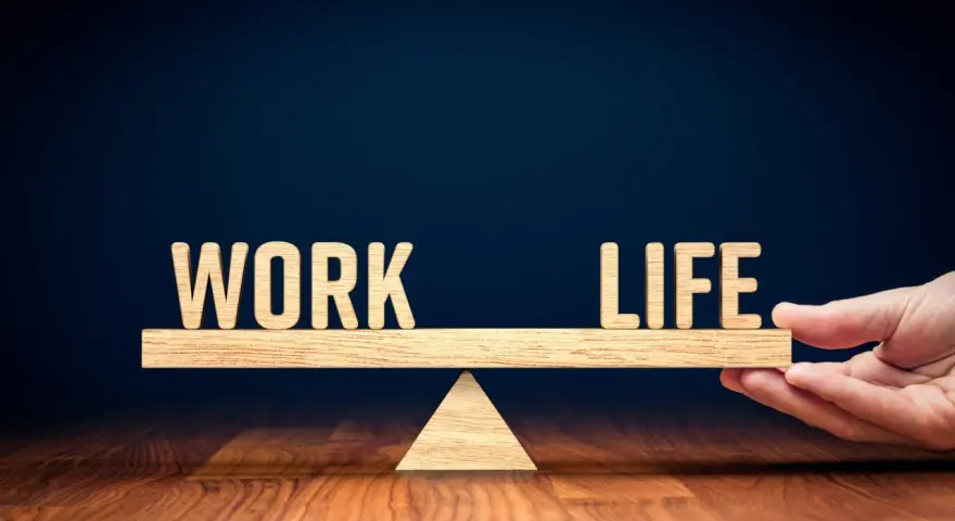 Waga symbolizująca work life balance co to jest. Drewniane litery "WORK" i "LIFE" na szali.
